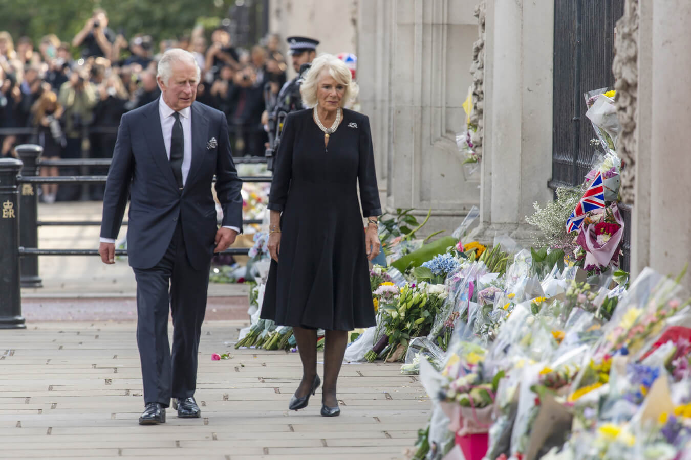 الملك تشارلز الثالث ودوقة كورنوال كاميلا ، قرينة ملكة المملكة المتحدة يشاهدان الزهور والرسائل خارج قصر باكنغهام بعد وفاة الملكة إليزابيث في لندن ، المملكة المتحدة في 9 سبتمبر 2022. وكالة )