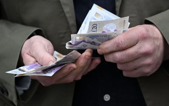 Person-holding-pound-notes-5458853